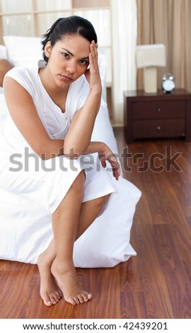 Angry woman sitting on the bed after having a row with her husband