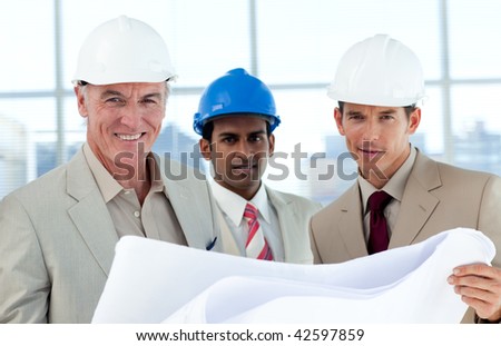 Smiling architects studying blueprints in a building