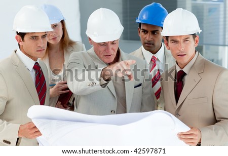 Multi-ethnic engineers studying plans in a building site