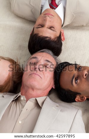 International business team lying on the floor with heads together
