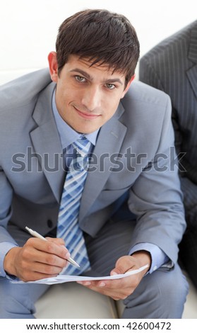 businessman writing and sitting in a waiting room