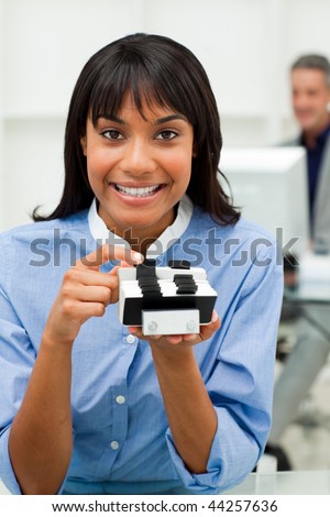 Self-assured businesswoman holding a business card holder in the office