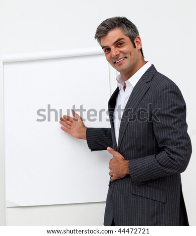 Self-assured male executive pointing at a board at a presentation