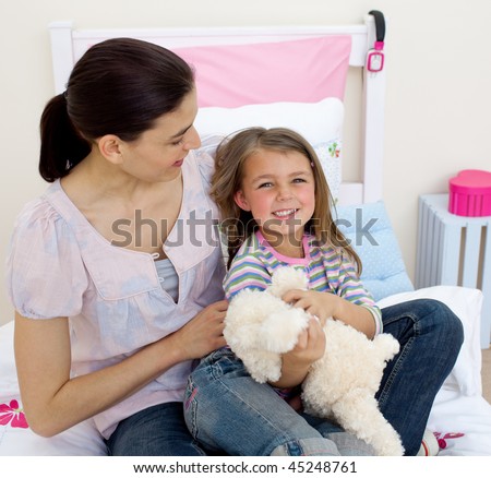 Happy mother and her daughter having fun in the bedroom
