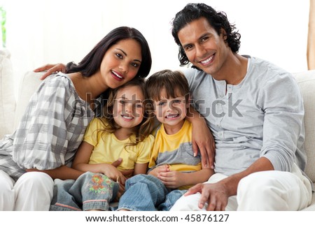 Cheerful family relaxing sitting on a sofa in their living room