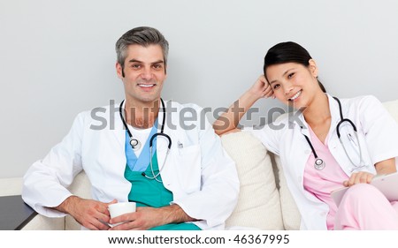 Two doctors relaxing and drinking coffee in the staff room