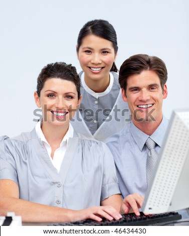 Smiling business people working at a computer in a company