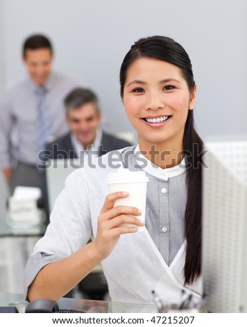 Asian woman drinking coffee in the office in a company