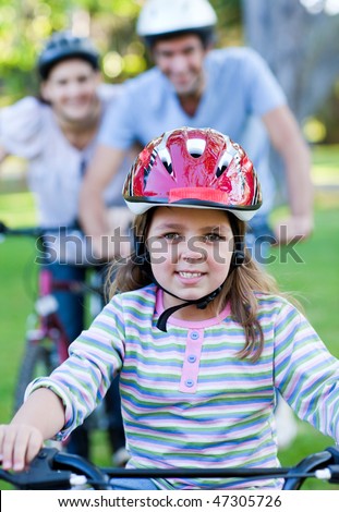 Cute little girl riding a bike in a park