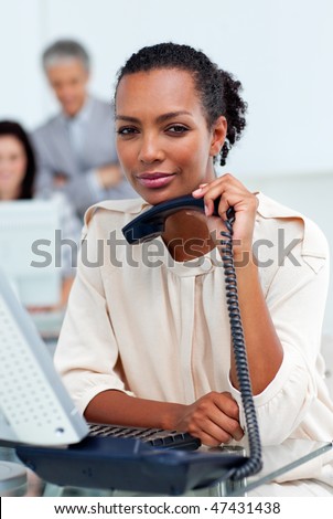 Pensive businesswoman holding a phone in an office