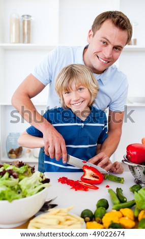 Cheerful father and his son cooking at home
