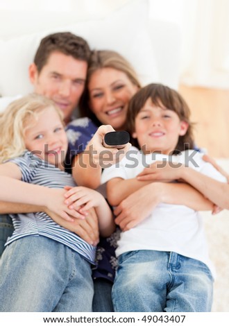 United family watching television sitting on sofa at home