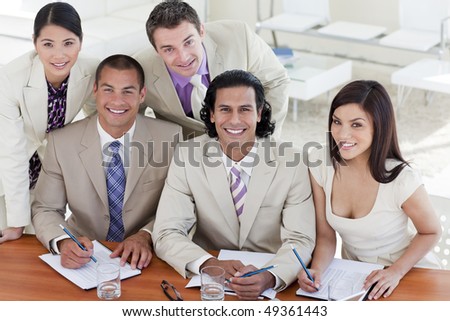 Cheerful business team in a meeting smiling at the camera