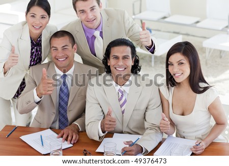 Successful business team with thumbs up in a meeting