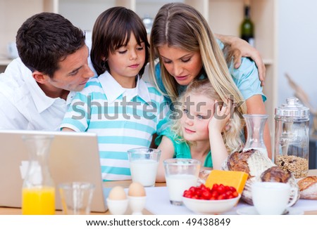 Happy family using laptop during the breakfast in the kitchen