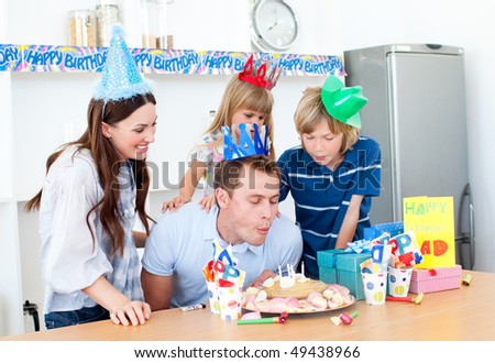 Elegant man celebrating his birthday with his wife and his children in the kitchen