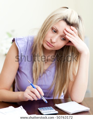 Stressed woman paying her bills in a living-room