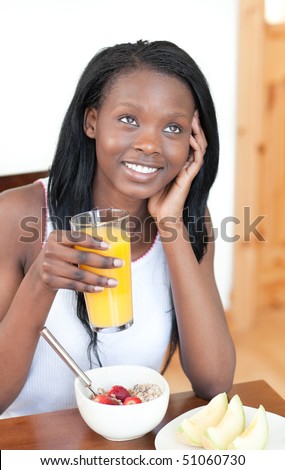 Charming Afro-American having breakfast in the living-room
