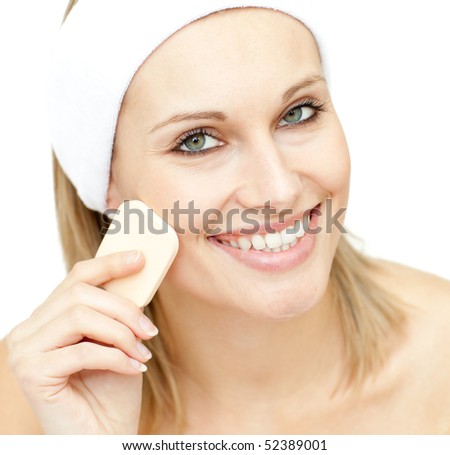 Cheerful woman putting foundation cream against a white background