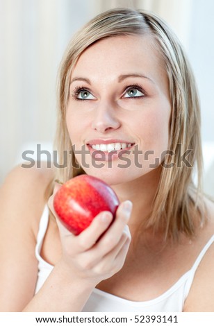 Beautiful woman eating an apple at home