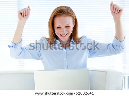 Radiant business woman punching the air in the office