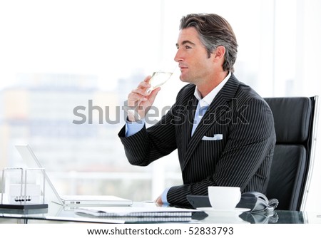 Charismatic businessman drinking a glass of water in the office