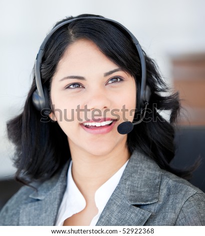Smiling businesswoman wearing a headset to talk with customer in the office