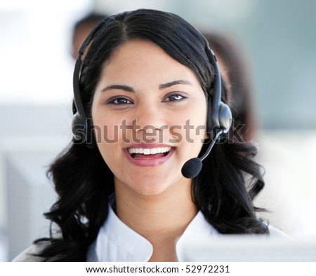 Beautiful businesswoman wearing a headset to talk with customer in the office