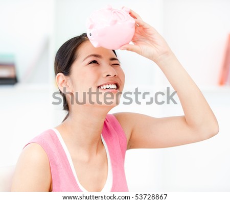 Portrait of a smiling businesswoman holding a piggy-bank in the office