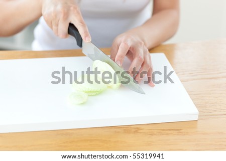 Delighted woman preparing onion in the kitchen at home