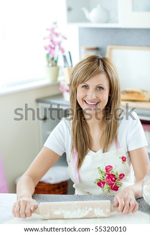Portrait of a delighted woman preparing a cake  in the kitchen at home
