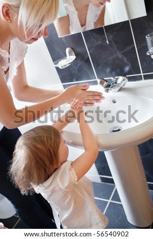 Mother and cute child washing their hands in the bathroom