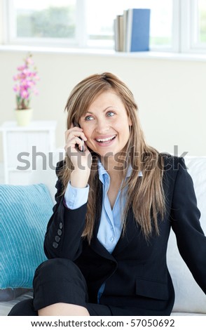 Radiant woman on phone sitting on a sofa in the office