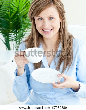 Attractive businesswoman holding a cup smiling at the camera