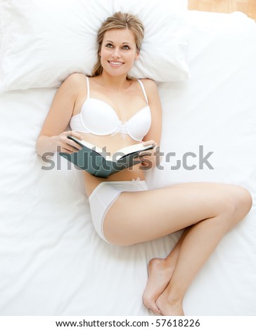 Simper woman reading a book in bed