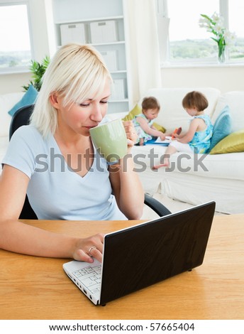 Relaxed working with her children at laptop in living room