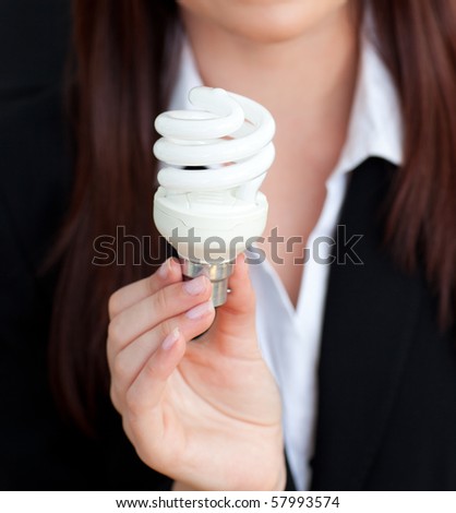 Close-up of a young businesswoman holding a light bulb in her office