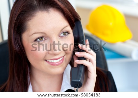 Self-assured female architecture talking on phone sitting in her office