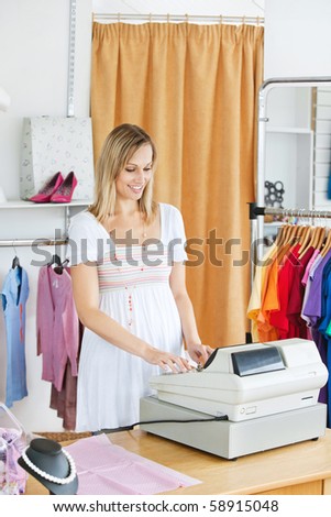 Elegant saleswoman standing at the cash register in a clothes store