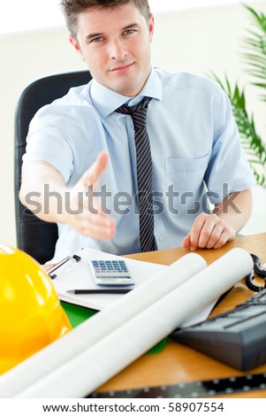 Confident businessman reaching his hand to the camera in his office