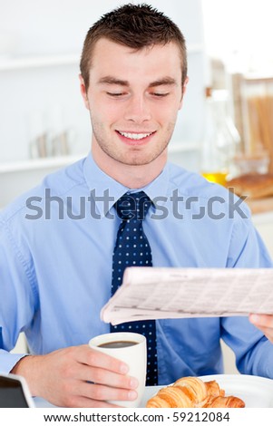 Happy businessman reading the newspaper drinking coffee in the morning at home