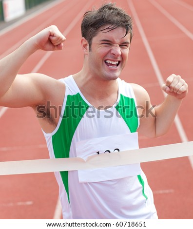 Exulting sprinter showing expression of victory in front of the arrival line in a stadium