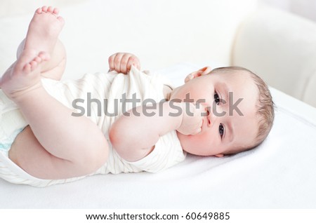 Adorable baby lying on the back in the living-room at home