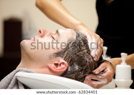 Close-up of a young caucasian man having his hair washed in a hairdressing salon