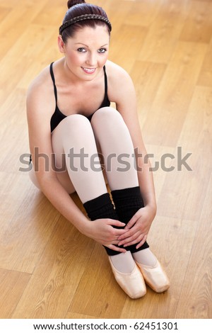 Portrait of a beautiful ballerina sitting on the floor
