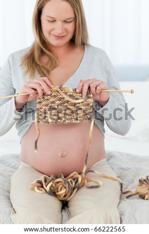 Young future mom knitting sitting in her bedroom