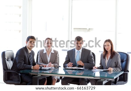 Serious business team sitting around a table during a meeting