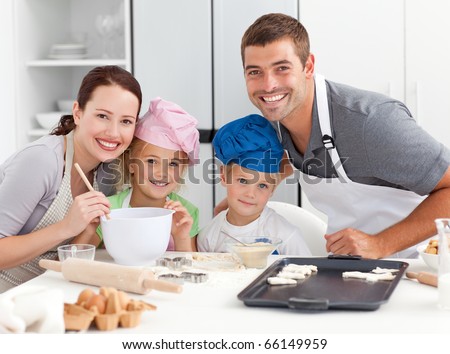 Portrait of a joyful family cooking little cakes in the kitchen