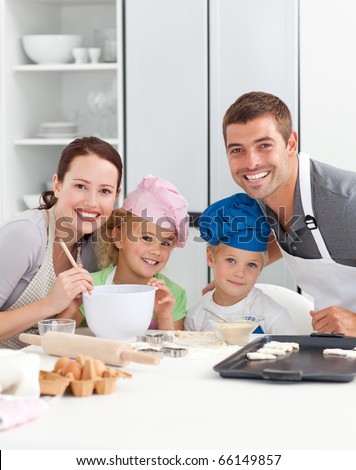 Portrait of a joyful family cooking cakes in the kitchen