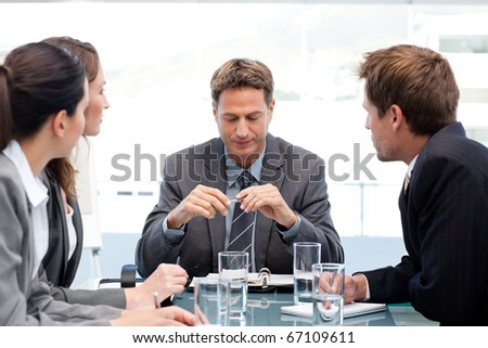 Serious manager at a table with his team during a meeting at the office